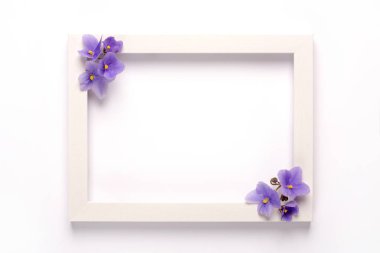 Mor çiçekler, beyaz arka plan üzerinde fotoğraf çerçevesi. Üst görünüm, kopyalama alanı. Düz yatıyordu.