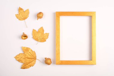 Sonbahar kompozisyonu. Altın yapraklar, meşe palamudu ve hafif bir arka plan üzerinde fotoğraf çerçevesi. Üst te. Kopyalama alanı