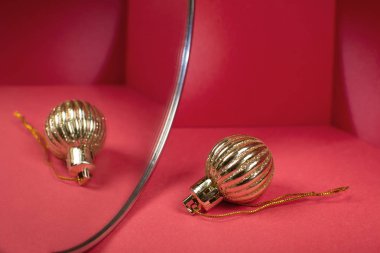 Altın top kırmızı arka plandaki aynaya yansıyor..