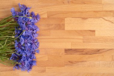 Ahşap bir arka planda mavi çiçek buketi. Üst görünüm, alanı kopyala.