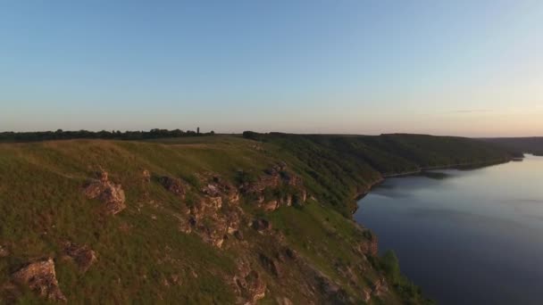 Vol de drone aérien majestueux à travers le paysage ukrainien rivière Dnister. Rivage escarpé avec des pierres. La nature sans personne. Coucher de soleil. 4K 