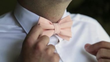 Düğün için. Damat elleri düğün gömleği içinde kelebeği düzeltir. Düğün modası. Yaz.