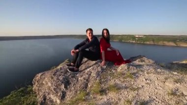 İki nehir kenarında oturan aşık. Günbatımı ışık.