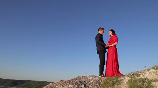 Couple in love kissing on the rivers edge. Sunset light. — Stock Video