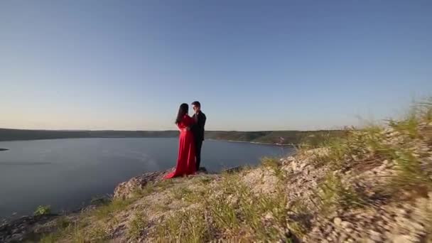 Par i Kärlek Kyssar på floder kanten. Solnedgången ljus. — Stockvideo