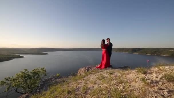 Par i Kärlek Kyssar på floder kanten. Solnedgången ljus. — Stockvideo