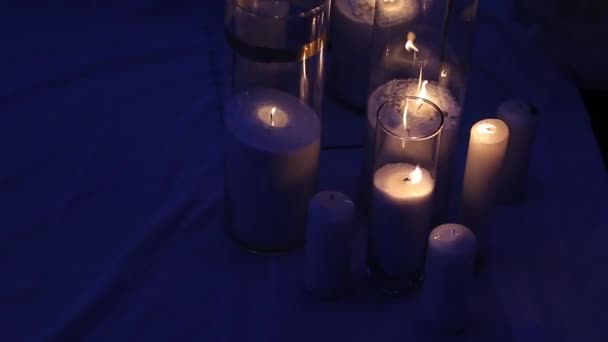 Świece w butelkach i szklanych pudełkach na ceremonii ślubnej na zewnątrz późno wieczorem. Romantyczne oświetlenie. — Wideo stockowe