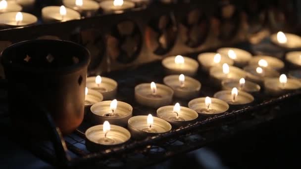 Candles light in church. Dark background. — Stockvideo