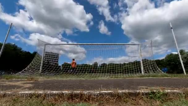Τα σύννεφα του χρόνου επιπλέουν στον ουρανό κατά τη διάρκεια του ποδοσφαιρικού αγώνα. Κάμερα τοποθετημένη πίσω από ένα στόχο. — Αρχείο Βίντεο