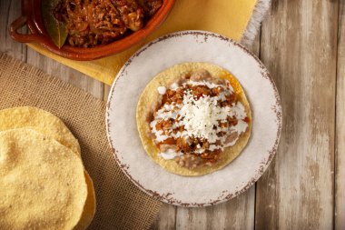 Köfteli tinga tostu, Meksika usulü geleneksel ev yapımı et, öncelikle acı biberli ve bol soğanlı, geleneksel olarak Tostadas 'ta yenir (kızarmış mısır tortillası).).