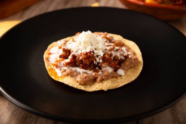 Köfteli tinga tostu, Meksika usulü geleneksel ev yapımı et, öncelikle acı biberli ve bol soğanlı, geleneksel olarak Tostadas 'ta yenir (kızarmış mısır tortillası).).