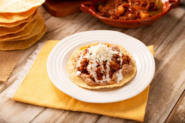 Köfteli tinga tostu, Meksika usulü geleneksel ev yapımı et, öncelikle acı biberli ve bol soğanlı, geleneksel olarak Tostadas 'ta yenir (kızarmış mısır tortillası).).