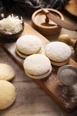 Alfajore 'lar. Latin Amerika 'da popüler olan geleneksel bir kurabiye, toz şeker, rendelenmiş hindistan cevizi veya çikolatayla kaplı bir sandviç oluşturan dulce de leche ile birleştirilmiş iki kurabiyeden oluşur..