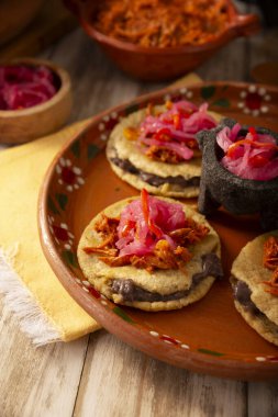 Panuchos, Meksika, Yucatan 'dan tipik bir yemek. El yapımı, fasulyeyle doldurulmuş kızarmış mısır tortilla, üzeri kakaolu pibil, turşulu kırmızı soğan ve habanero biberi..
