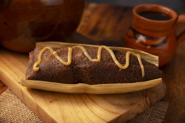 Çikolatalı Tamale. Meksika ve bazı Latin Amerika ülkelerinin tipik İspanyol yemekleri. Mısır yaprağına sarılmış mısır hamuru. Tamaleler buğulandı. Yanında genellikle atole, sıcak çikolata ya da kahve olur.