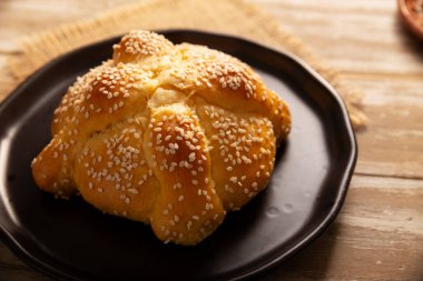 Pan de Muerto. Ölü sezonunda tüketilen susam tohumlu tipik Meksika tatlı ekmeği. Sunaklarda ve sunaklarda temel bir unsurdur..