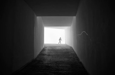 ışık ve karanlık bir koridor sonundaki adam silüeti