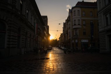 Szeged, Macaristan - 23 Haziran 2017: batan güneş parlar Szeged boş sokaklarda
