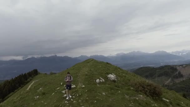 Hombre atlético corriendo en la cima de una montaña y panorama — Vídeos de Stock