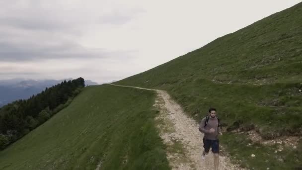 Hombre atlético joven explorando montañas y corriendo — Vídeo de stock