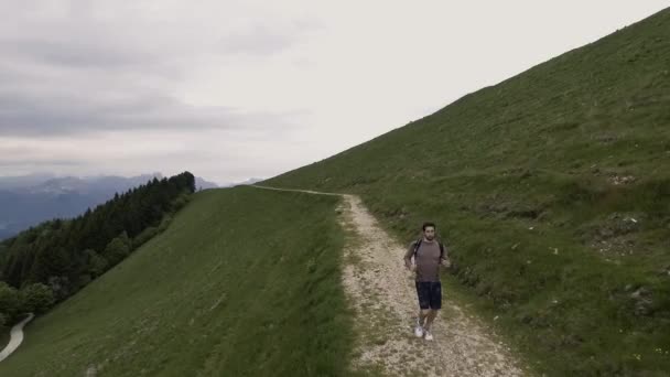 Hombre atlético joven explorando montañas y corriendo — Vídeos de Stock