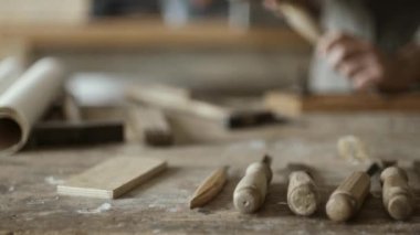 Çekiç ve keski ve ağaç işleme aletleri bir dizi ön planda kullanarak profesyonel yetenekli marangoz oyma ahşap