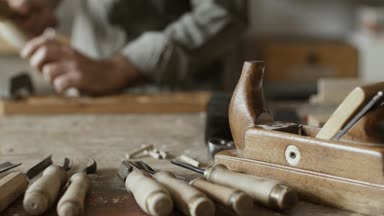Çekiç ve keski ve ağaç işleme aletleri bir dizi ön planda kullanarak profesyonel yetenekli marangoz oyma ahşap