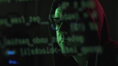 Hacker gözlük ve kapüşonlu ile o bilgisayar ekranında, siber suç çalıştıran ve kavramı kesmek kod izliyor