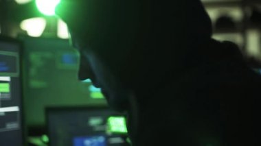 Profesyonel hacker birden fazla cihaz ile çalışma veri aktarımı bilgisayar ekranlarında ve onun Smartphone cep telefonu ile kontrol ediyor