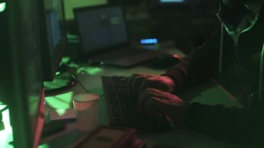 Siyah şapkalı hacker ile çalışan birden çok ekranlar ve kesmek sistemleri, siber suç ve güvenlik kavramı ile hoodie