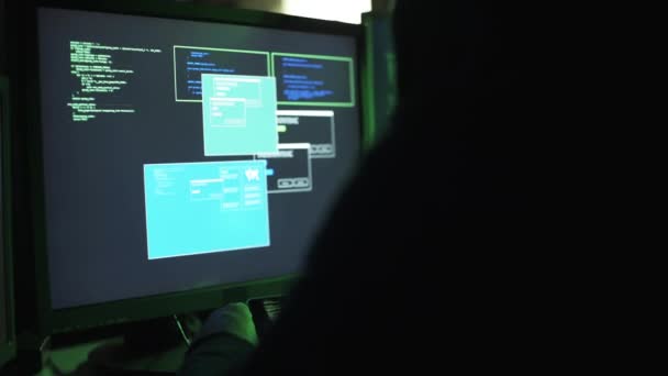 複数のデバイスを扱うプロのハッカー彼はコンピューターの画面上および彼のスマート フォンのデータ転送をチェック — ストック動画