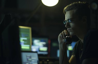 Bununla birlikte güneş gözlüklü bir telefon ahizesi ve bilgisayar ekranları, kodlama ve sistem kavramı kesmek kesmek