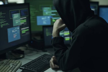 Genç hacker ile çene üzerinde el ile hoodie düşünme ve çalışma ile bilgisayarlar, teknoloji ve siber suçlar kavramı