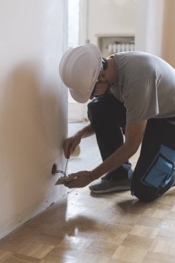 Profesyonel elektrikçi yuva bir tornavida kullanarak yükleme: ev yenileme ve bakım kavramı