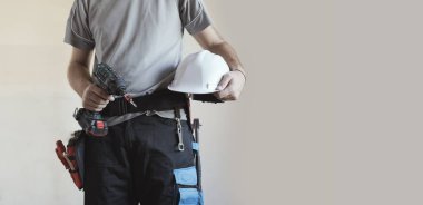 İnşaat işçisi kask ve matkap, ev yenileme ve inşaat kavramı ile poz