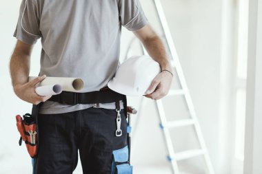Holding kağıt rulo ve bir kask, ev yenileme ve mimari konsept profesyonel inşaat mühendisi