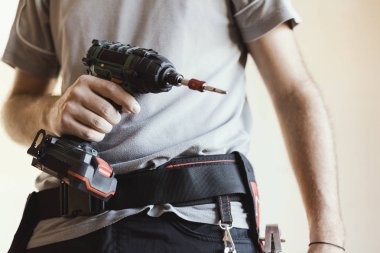 İnşaat işçisi kask ve matkap, ev yenileme ve inşaat kavramı ile poz