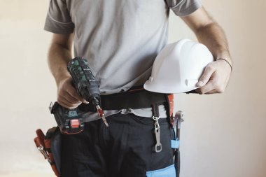 İnşaat işçisi kask ve matkap, ev yenileme ve inşaat kavramı ile poz