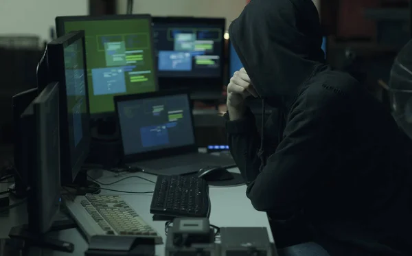 酷年轻的黑客与帽衫工作的计算机 网络犯罪和数据安全概念 — 图库照片