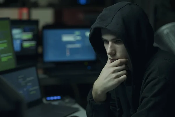 酷年轻的黑客与帽衫工作的计算机 网络犯罪和数据安全概念 — 图库照片