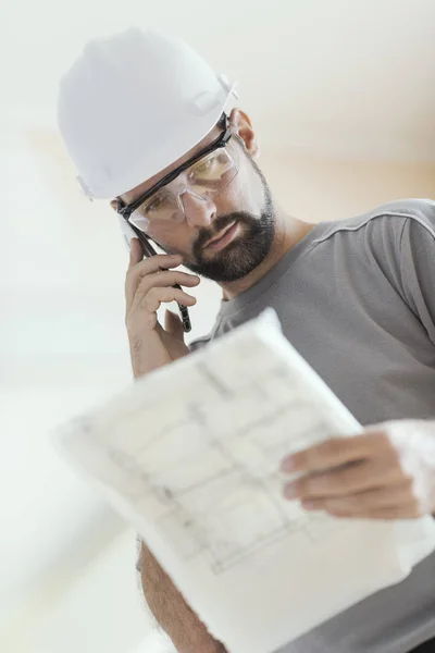 Professionell Byggnadsarbetare Kontroll Hus Projektet Och Ringer Med Sin Smartphone — Stockfoto