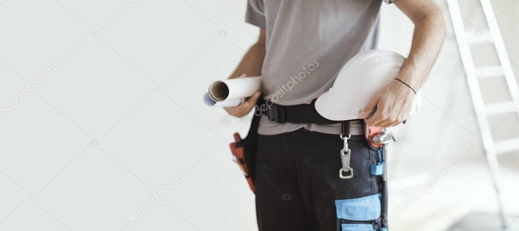 Professional construction engineer holding paper rolls and a safety helmet, home renovation and architecture concept