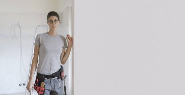Alet kemeri ile poz ve gülümseyerek kameraya, kadın uzmanları kavramı kendine güvenen kadın yüklenici