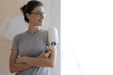 Bir rulo ile poz ve uzak seyir emin gülümseyen kadın: ev yenileme ve tadilat concept