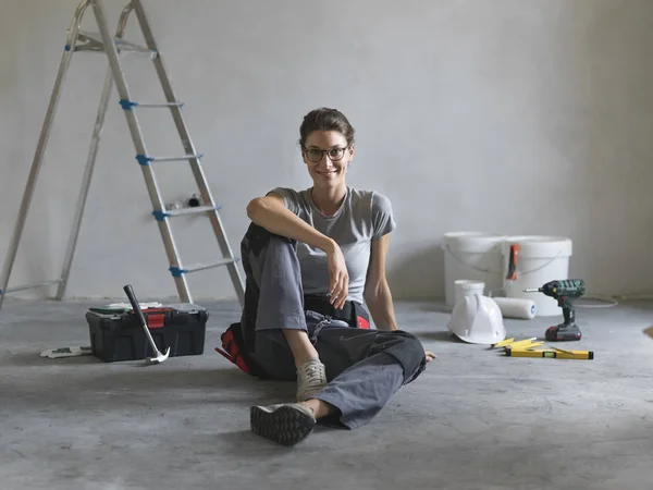 Profesjonalne Repairwoman Robiąc Remont Domu Ona Siedzi Podłodze Uśmiecha Się — Zdjęcie stockowe