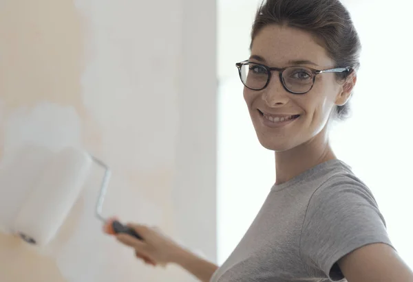 Smiling young woman painting walls in her new house: home renovation and DIY concept — Stock Image Smiling Young Woman Painting Walls Her New House Home Renovation Royalty Free Stock Photos