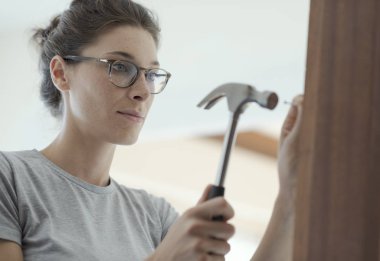 Kadın eve bir çekiç kullanarak, bir kapı tamiri: ev yenileme ve DIY kavramı