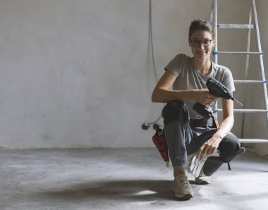 Profesyonel repairwoman bir ev yenileme yapıyor alet kemeri ile o poz ve tatbikat holding