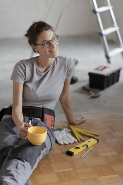 Genç gülümseyen bir kahve molası verdikten ve katta oturan kadın, o ev yenileme yapıyor