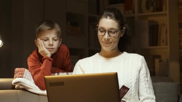 快乐的女人和儿子一起在家里用笔记本电脑和信用卡网上购物 — 图库视频影像